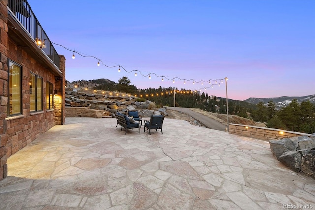 patio terrace at dusk featuring a mountain view