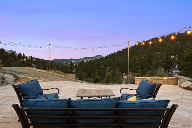 patio terrace at dusk featuring a mountain view and outdoor lounge area