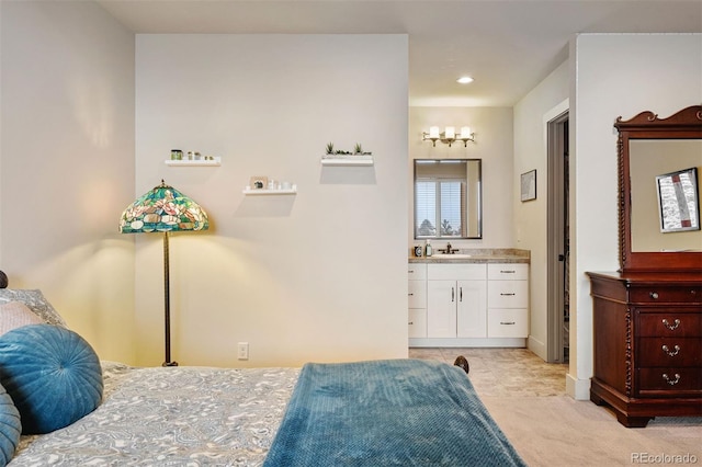 carpeted bedroom featuring sink and ensuite bath