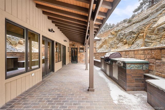 view of patio with exterior kitchen and a grill