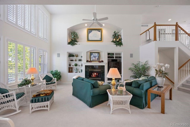 9278 E Aspen Hill Pl, Lone Tree, CO 80124 - carpeted living room with a high ceiling, built in shelves, stairway, ceiling fan, and a high end fireplace