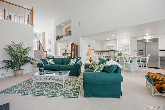 9278 E Aspen Hill Pl, Lone Tree, CO 80124 - living area with a towering ceiling, stairs, recessed lighting, and light colored carpet