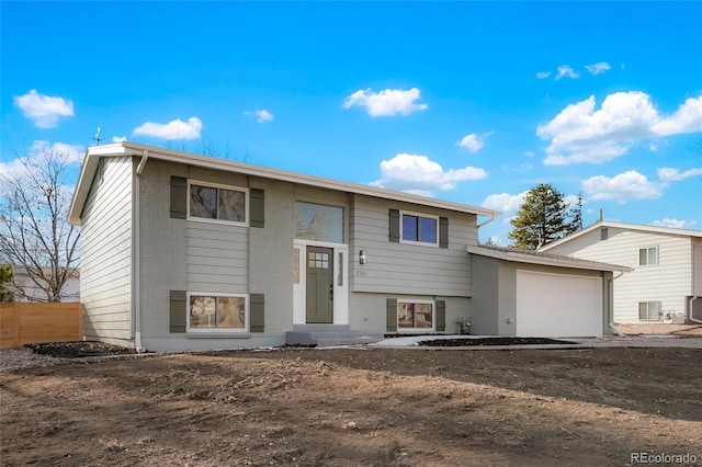 bi-level home featuring central AC and a garage