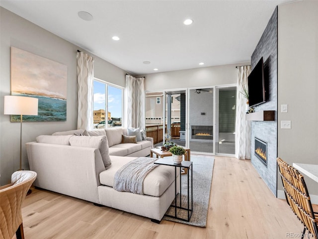 living room with light wood-type flooring and a large fireplace