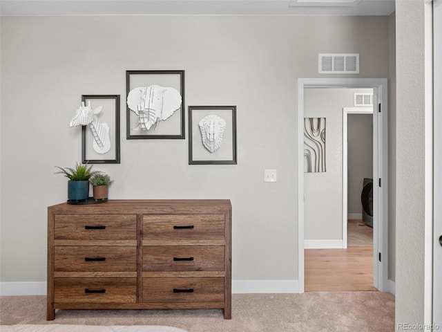 hall featuring washer / dryer and light carpet