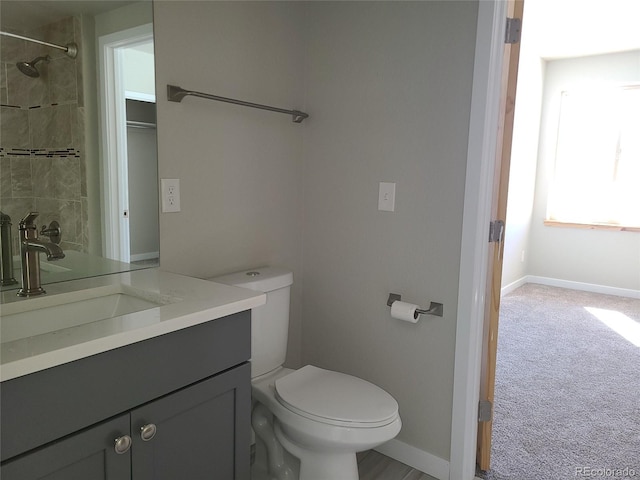 bathroom with vanity, toilet, and baseboards