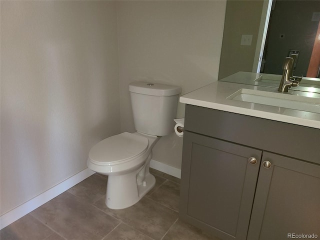 bathroom with tile patterned flooring, baseboards, vanity, and toilet