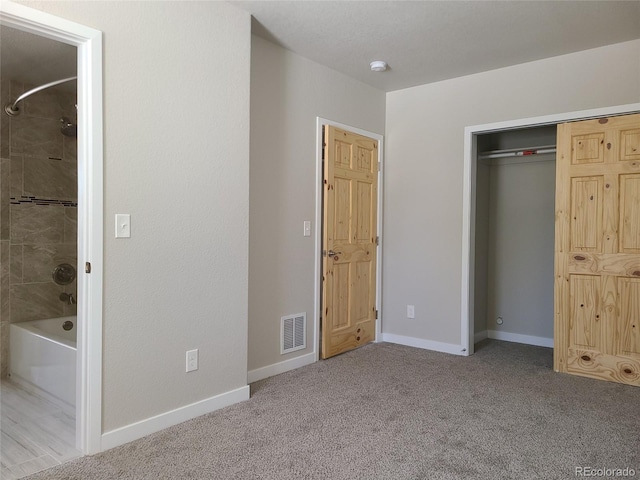 unfurnished bedroom featuring baseboards, a closet, visible vents, and light colored carpet