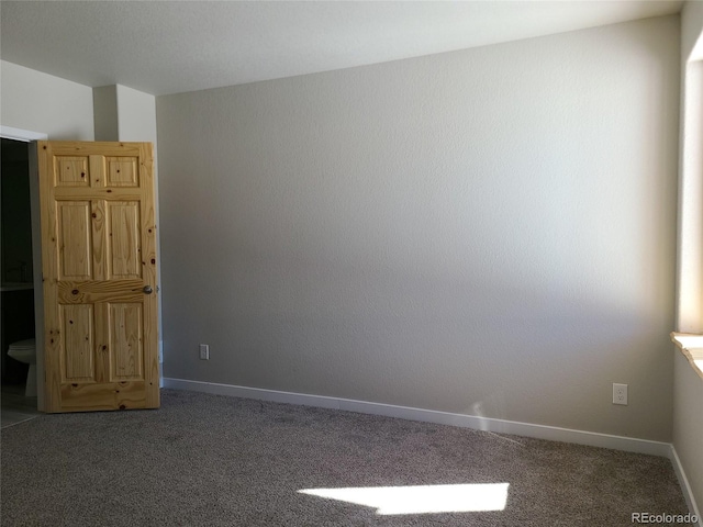 empty room with carpet and baseboards