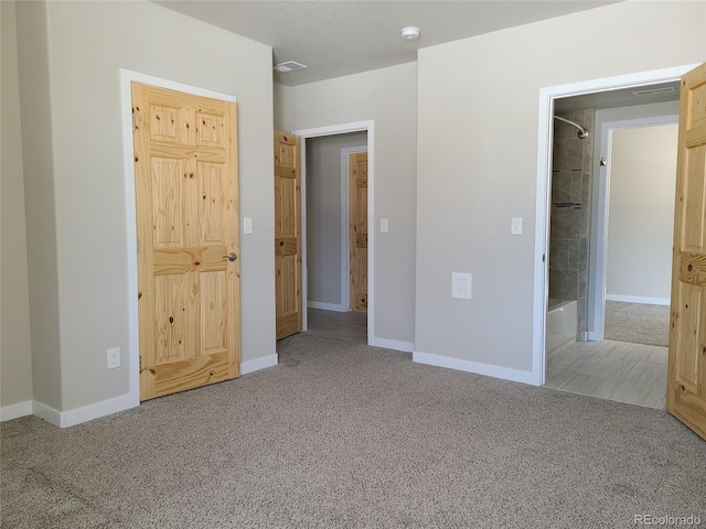 unfurnished bedroom featuring carpet flooring, visible vents, and baseboards