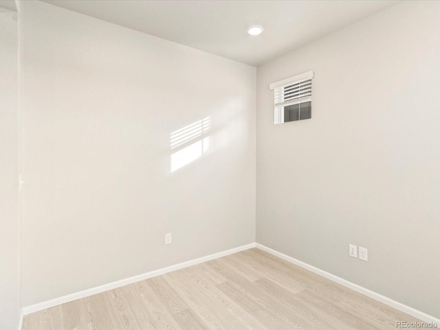 unfurnished room with light wood-type flooring and baseboards