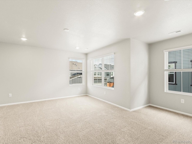 empty room with visible vents, carpet flooring, and baseboards