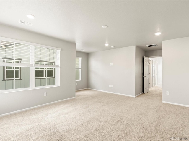 spare room featuring recessed lighting, carpet, visible vents, and baseboards