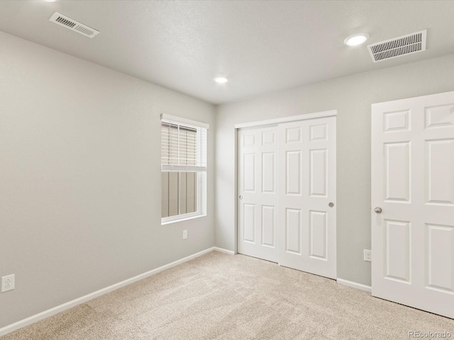 unfurnished bedroom featuring visible vents, baseboards, a closet, and carpet flooring