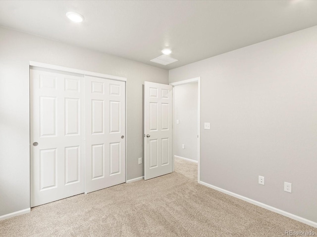 unfurnished bedroom with a closet, carpet flooring, visible vents, and baseboards