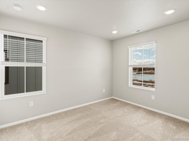 carpeted spare room with recessed lighting, visible vents, and baseboards