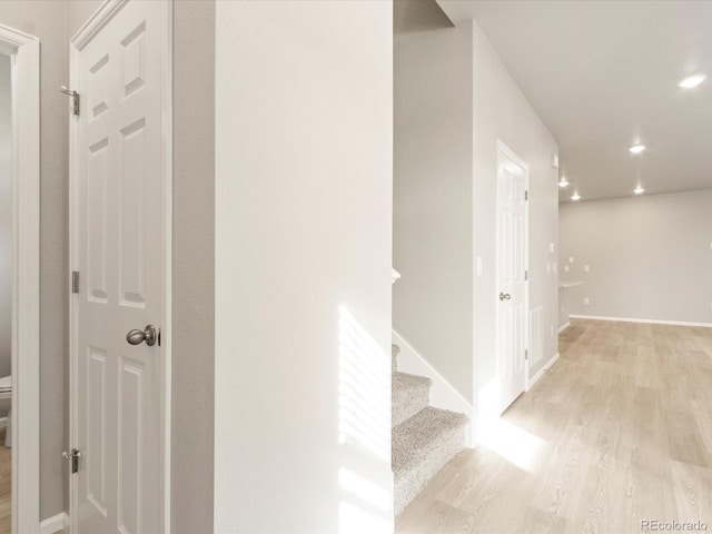 corridor with stairway, recessed lighting, light wood-style flooring, and baseboards