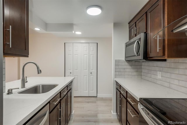 800 N Pearl St Unit 611, Denver, CO 80203 - kitchen featuring a sink, appliances with stainless steel finishes, dark brown cabinetry, recessed lighting, and light wood finished floors