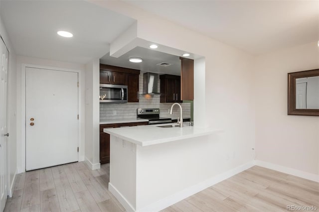 800 N Pearl St Unit 611, Denver, CO 80203 - kitchen featuring stainless steel appliances, a sink, wall chimney range hood, light wood-style flooring, and recessed lighting