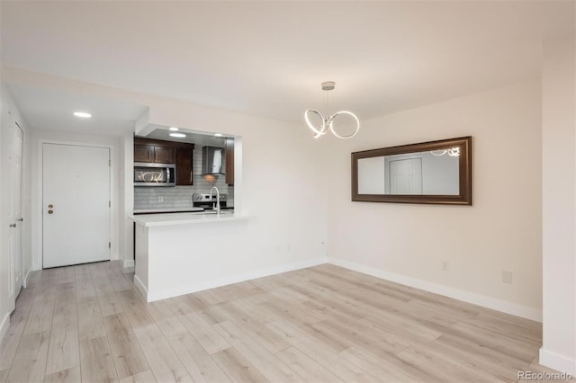 800 N Pearl St Unit 611, Denver, CO 80203 - kitchen with stainless steel microwave, dark brown cabinets, light wood finished floors, light countertops, and a peninsula