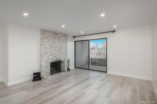 800 N Pearl St Unit 611, Denver, CO 80203 - unfurnished living room featuring wood finished floors, a brick fireplace, baseboards, and recessed lighting