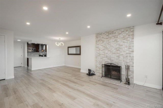 800 N Pearl St Unit 611, Denver, CO 80203 - unfurnished living room with light wood-style floors, a brick fireplace, recessed lighting, and baseboards