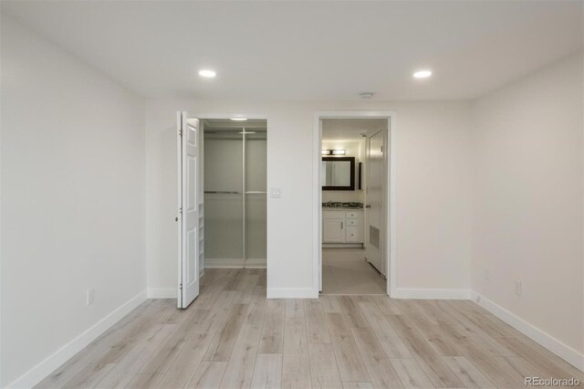 800 N Pearl St Unit 611, Denver, CO 80203 - unfurnished bedroom with light wood finished floors, recessed lighting, baseboards, and ensuite bathroom