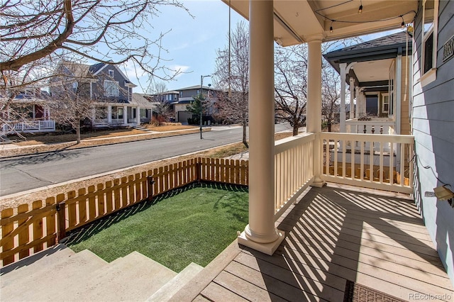 wooden terrace with a residential view and a porch