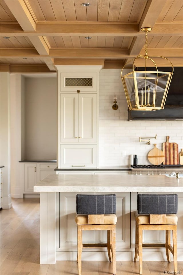 bar with hanging light fixtures, light hardwood / wood-style floors, beam ceiling, backsplash, and wooden ceiling