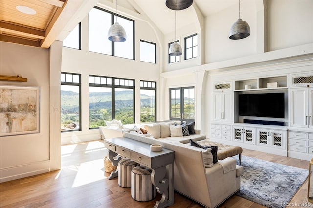 living room with french doors, wooden ceiling, a high ceiling, and light wood-type flooring