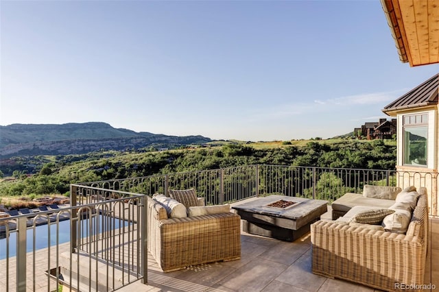 balcony with an outdoor living space with a fire pit and a mountain view