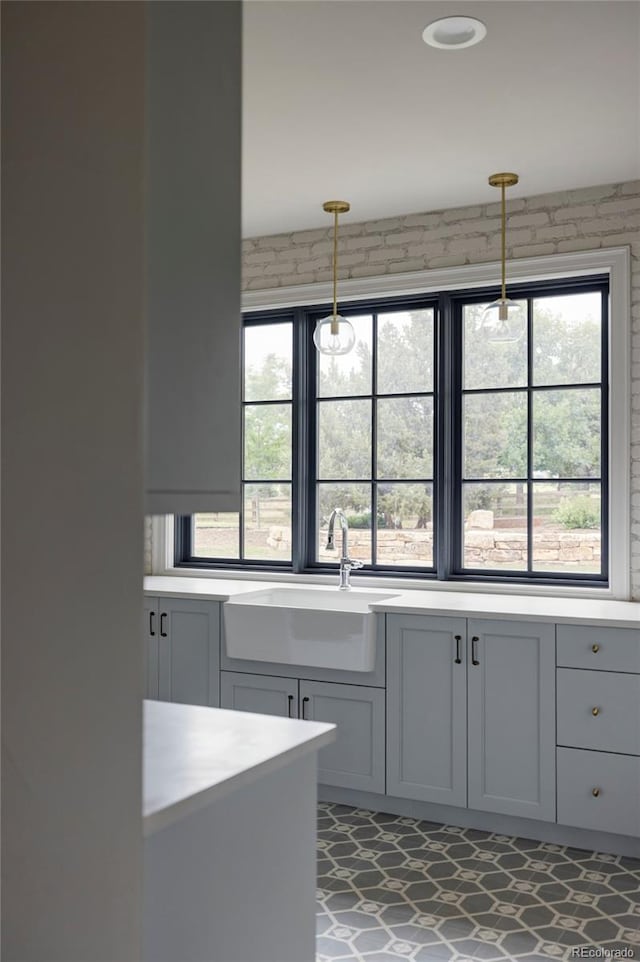 kitchen featuring sink, pendant lighting, a wealth of natural light, and gray cabinets