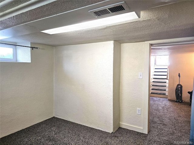 3798 S Grant St, Englewood, CO 80113 - basement featuring a textured wall, visible vents, and dark carpet