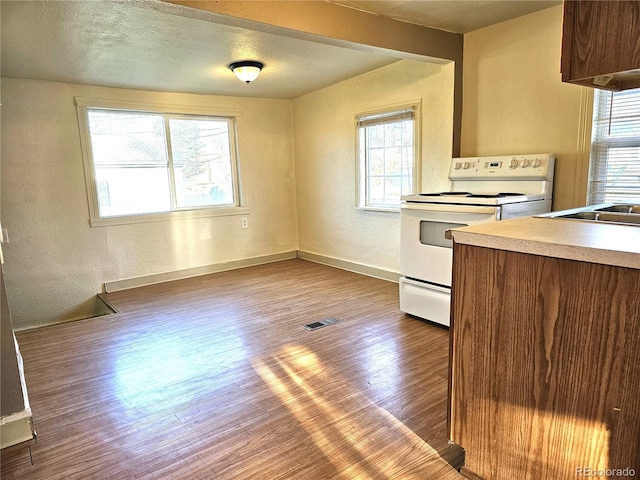 3798 S Grant St, Englewood, CO 80113 - kitchen featuring a textured wall, white range with electric cooktop, baseboards, wood finished floors, and visible vents