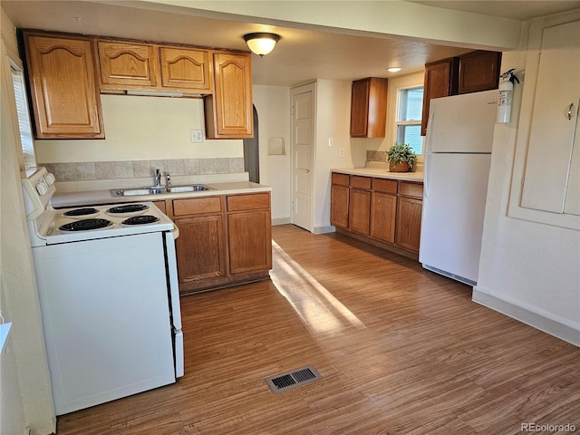 3798 S Grant St, Englewood, CO 80113 - kitchen featuring visible vents, wood finished floors, a sink, light countertops, and white appliances