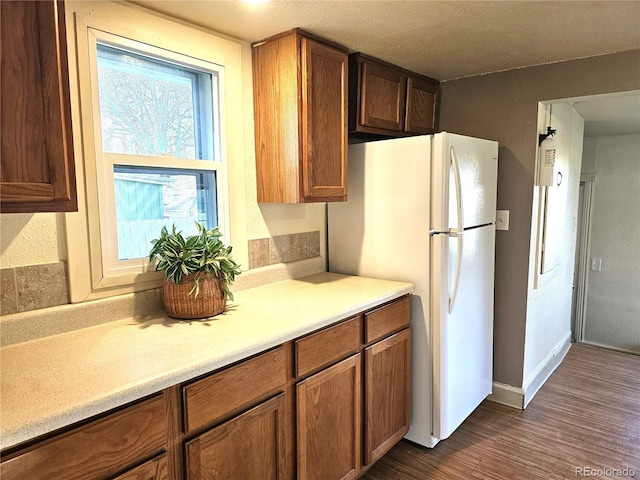 3798 S Grant St, Englewood, CO 80113 - kitchen featuring freestanding refrigerator, dark wood-style flooring, brown cabinets, and light countertops
