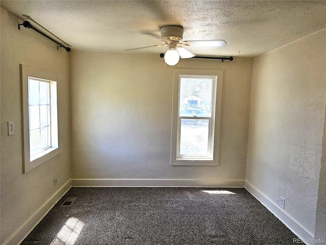 3798 S Grant St, Englewood, CO 80113 - empty room featuring a textured ceiling, a textured wall, a wealth of natural light, and dark colored carpet