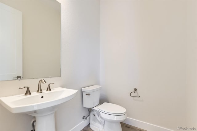 bathroom featuring sink, hardwood / wood-style floors, and toilet