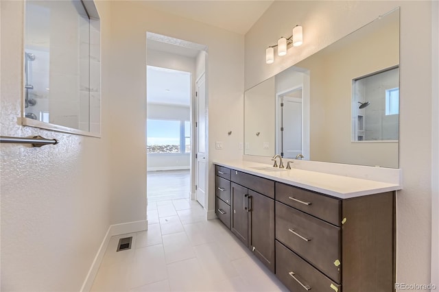 bathroom featuring vanity, tile patterned floors, and walk in shower