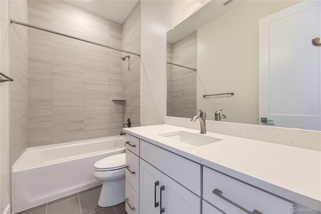 full bathroom with tile patterned flooring, tiled shower / bath combo, toilet, and vanity