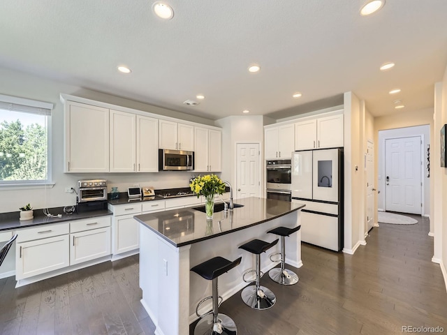3508 E 140th Pl, Thornton, CO 80602 - kitchen featuring appliances with stainless steel finishes, dark countertops, dark wood finished floors, and recessed lighting