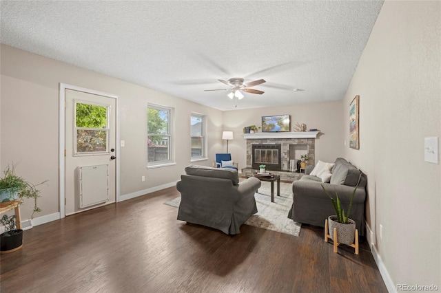 1285 Aberdeen Dr, Broomfield, CO 80020 - living room featuring ceiling fan, dark wood-type flooring, a textured ceiling, a glass covered fireplace, and baseboards
