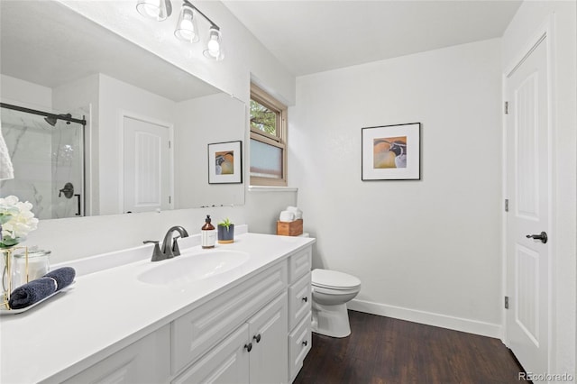 1285 Aberdeen Dr, Broomfield, CO 80020 - bathroom with a shower stall, baseboards, vanity, wood finished floors, and toilet