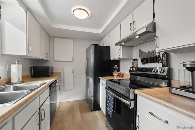 kitchen with a raised ceiling, appliances with stainless steel finishes, sink, and white cabinets