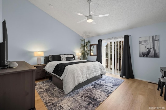 bedroom with lofted ceiling, access to outside, a textured ceiling, and light hardwood / wood-style floors