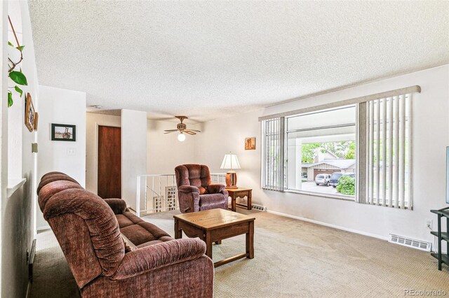 7503 Saulsbury St, Arvada, CO 80003 - carpeted living room featuring a textured ceiling, baseboards, and a ceiling fan
