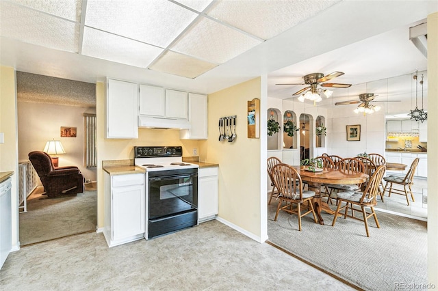 7503 Saulsbury St, Arvada, CO 80003 - kitchen with electric stove, light countertops, under cabinet range hood, white cabinets, and light carpet