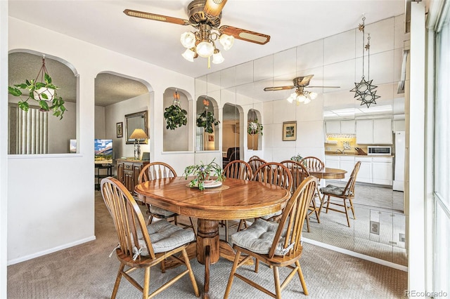 7503 Saulsbury St, Arvada, CO 80003 - dining room featuring ceiling fan, carpet flooring, arched walkways, and baseboards