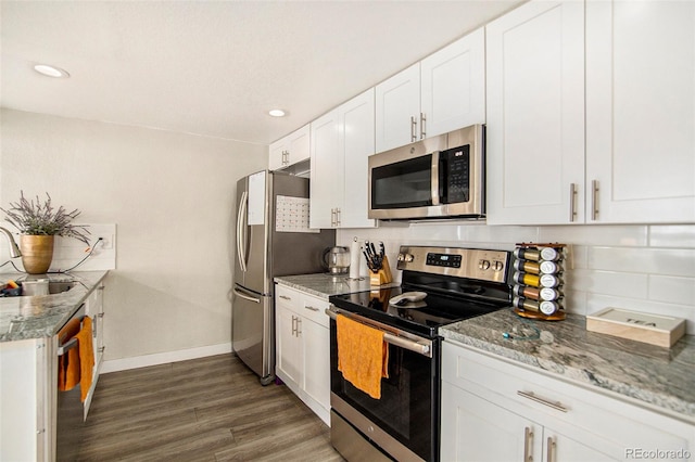 kitchen with white cabinets, stainless steel appliances, dark hardwood / wood-style floors, and light stone countertops