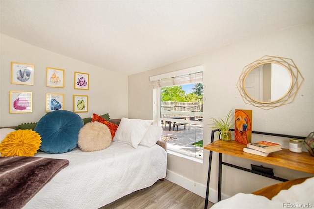 bedroom with vaulted ceiling and hardwood / wood-style flooring